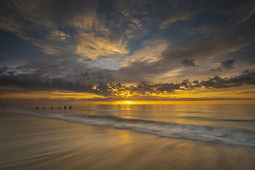 USA-New Jersey-Cape May National Seashore Sunrise on pier posts on ocean shore Beach Print